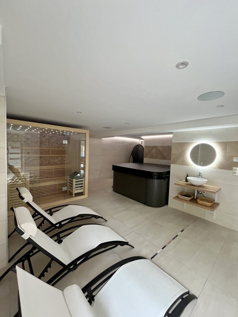 Espace détente avec jacuzzi, sauna, transat, fauteuil oeuf et double douche